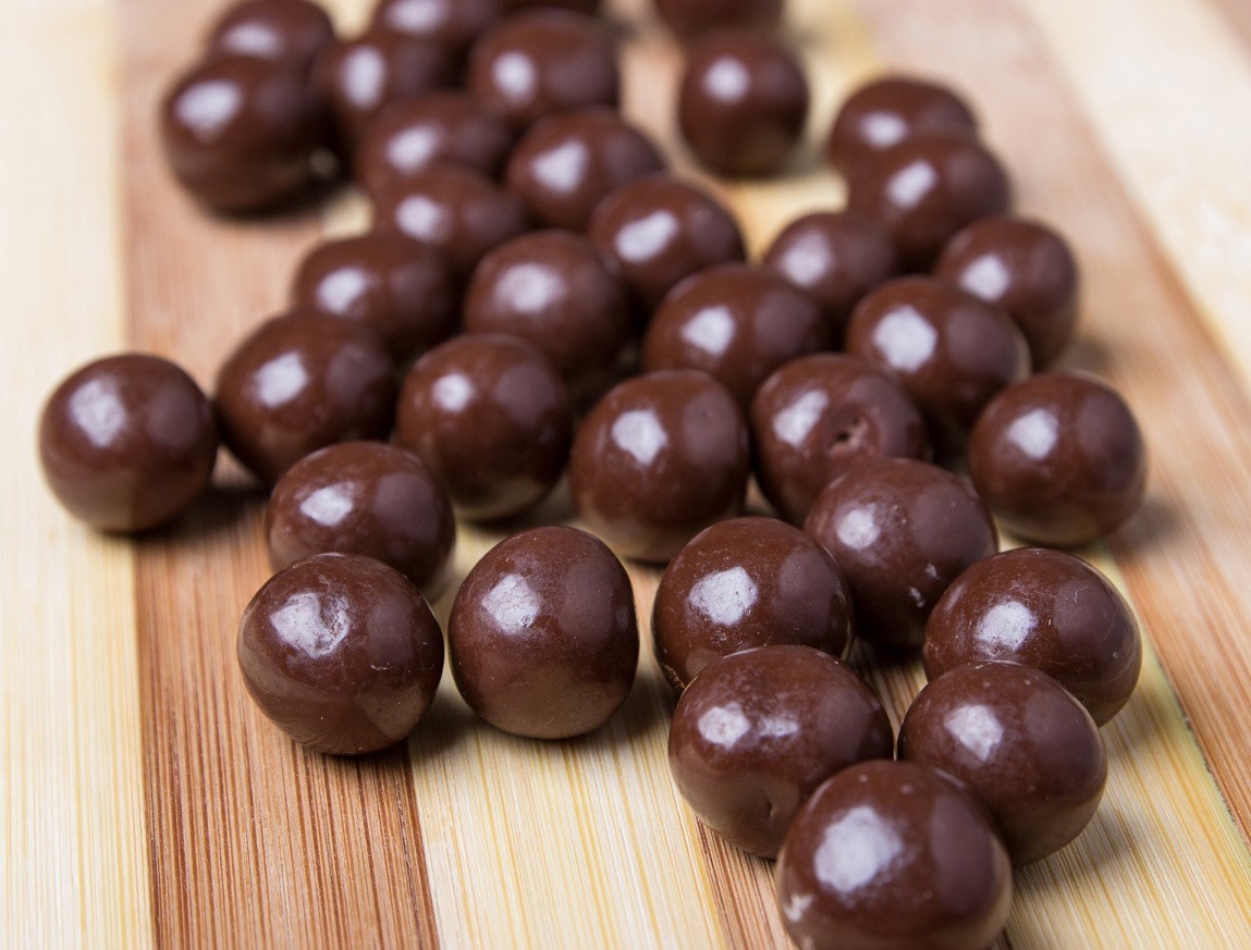 Round chocolate candies on the wooden table Alland & Robert