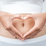 Close up of woman's hands made heart on belly isolated on white background.health care concept.